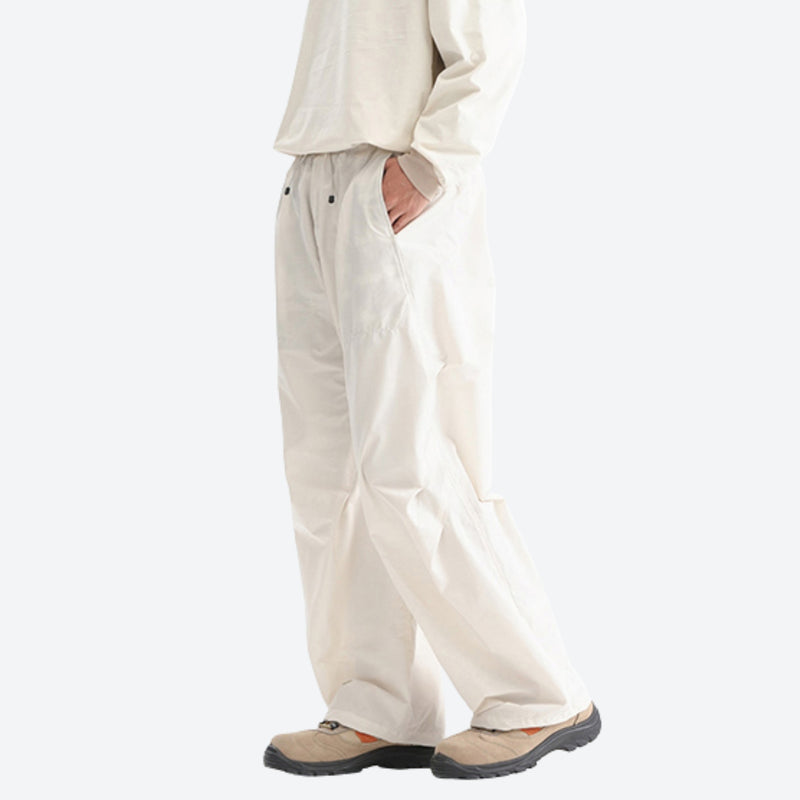Water-repellent nylon hiking pants with relaxed fit - cream white wide-leg hiking pants with cream top, side walking view