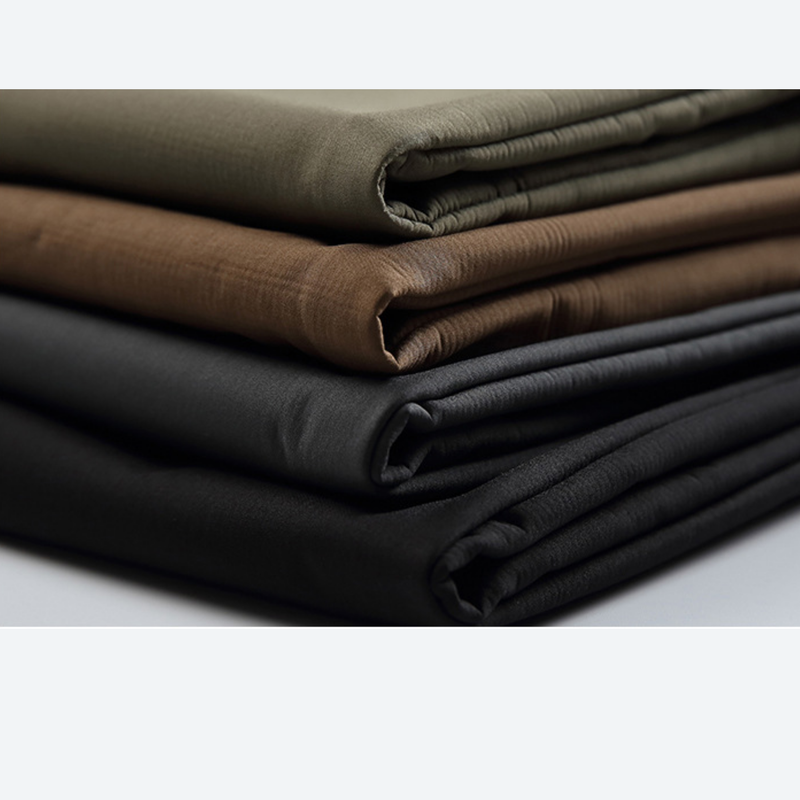 Men's 3-proof cargo pants with fleece lining - olive brown black, folded fabric stack close-up, for cold-weather trekking