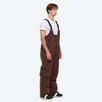 
                  
                    Unisex waterproof 2L snow jacket and bib pants - coffee brown bib pants, on-model side view, for cold-weather winter sports
                  
                