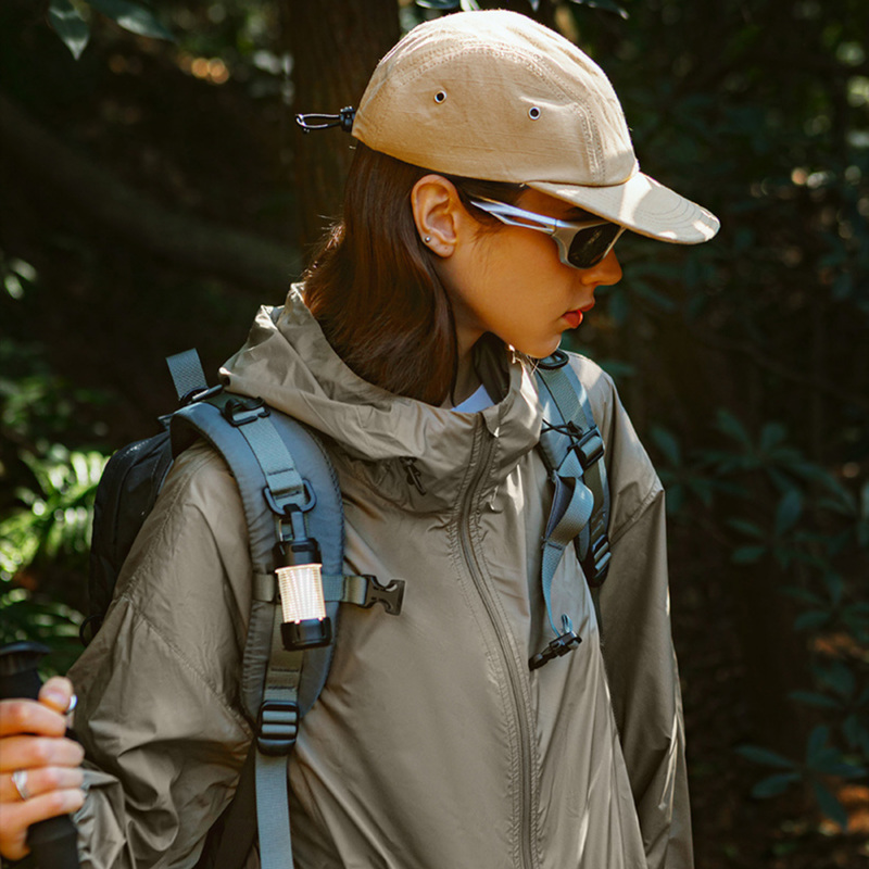 Waterproof sun protection jacket UPF50 - olive waterproof sun jacket on women with cap and backpack, close-up view