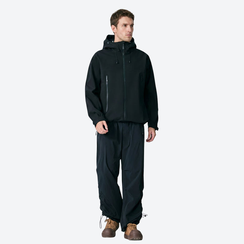Breathable lightweight shell with built-in carry straps - black hardshell jacket, full-body front view, for hiking and travel