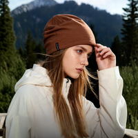 
                  
                    Fine 17.5 micron merino wool beanie - brown merino beanie on women, worn side view, for skiing and snowboarding
                  
                