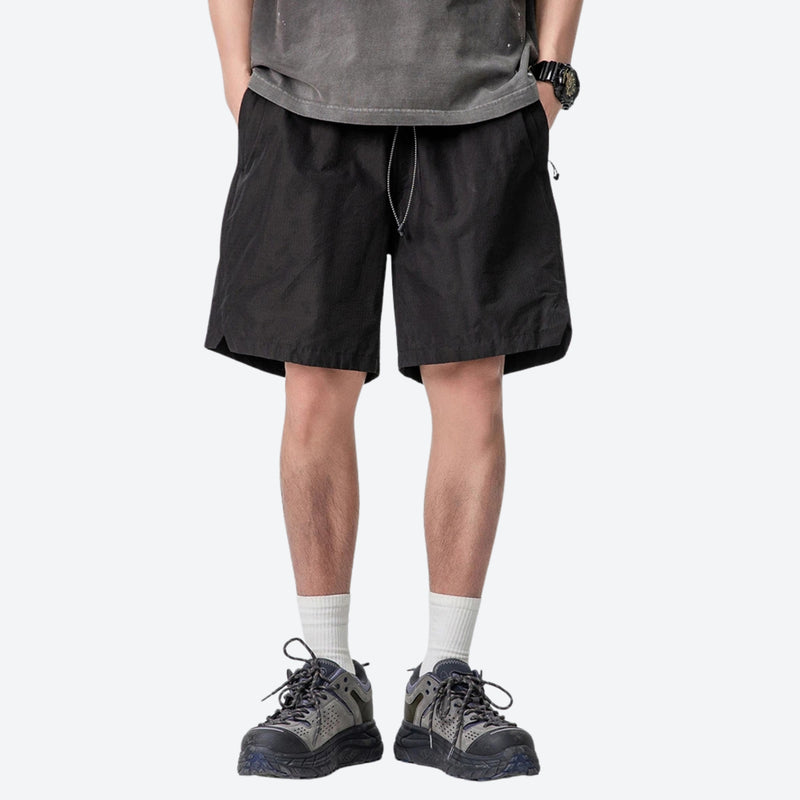 Unisex nylon quick-dry shorts - black quick-dry shorts with gray tee, front standing view, for travel and city walks