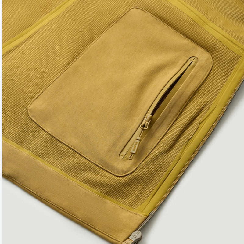 Unisex softshell snowboard jacket with welded seams - mustard, pocket flap close-up detail, for cold-weather winter sports