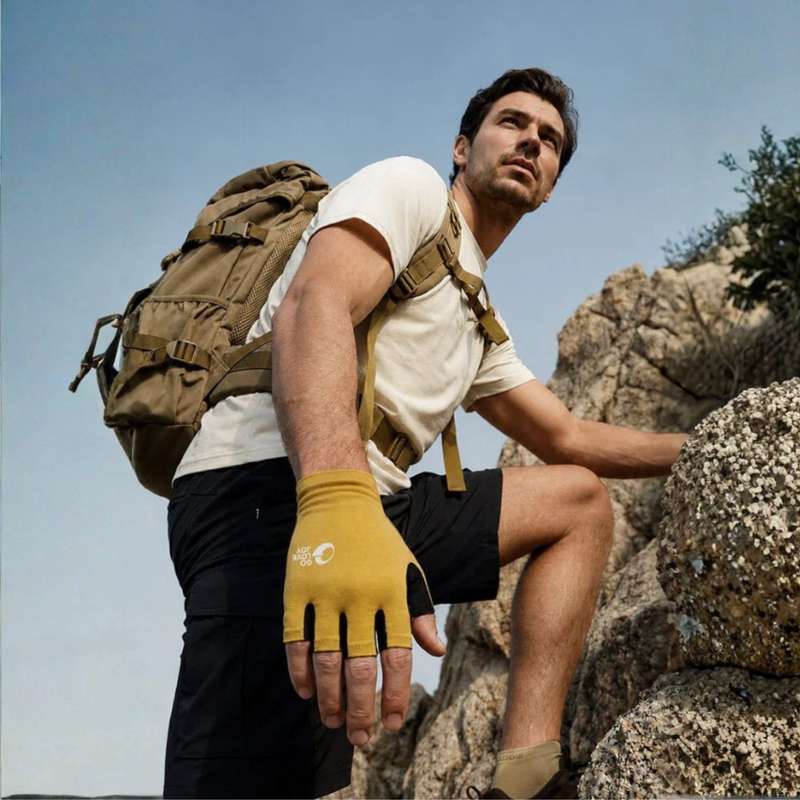 Merino wool full finger and half finger hiking gloves - mustard merino wool half finger gloves on men, rock sitting view