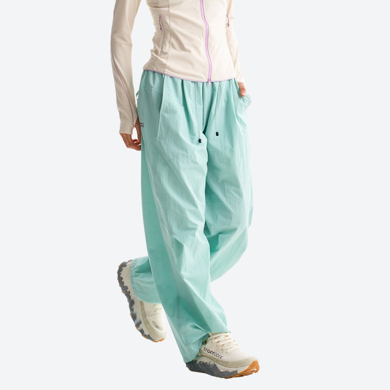 Water-repellent nylon hiking pants with relaxed fit - mint green wide-leg hiking pants with cream top, walking side view