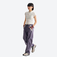 
                  
                    Breathable relaxed trail pants with drawcord waist - mauve purple quick-dry hiking pants with white tee, side walking view
                  
                
