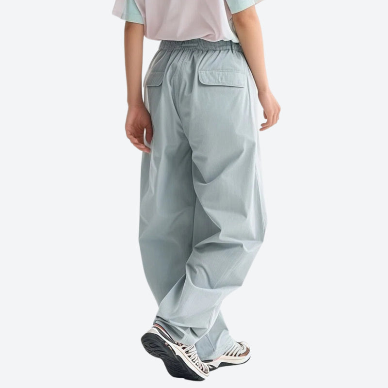 Lightweight water-repellent hiking pants with pockets - light blue quick-dry hiking pants with white tee, back walking view