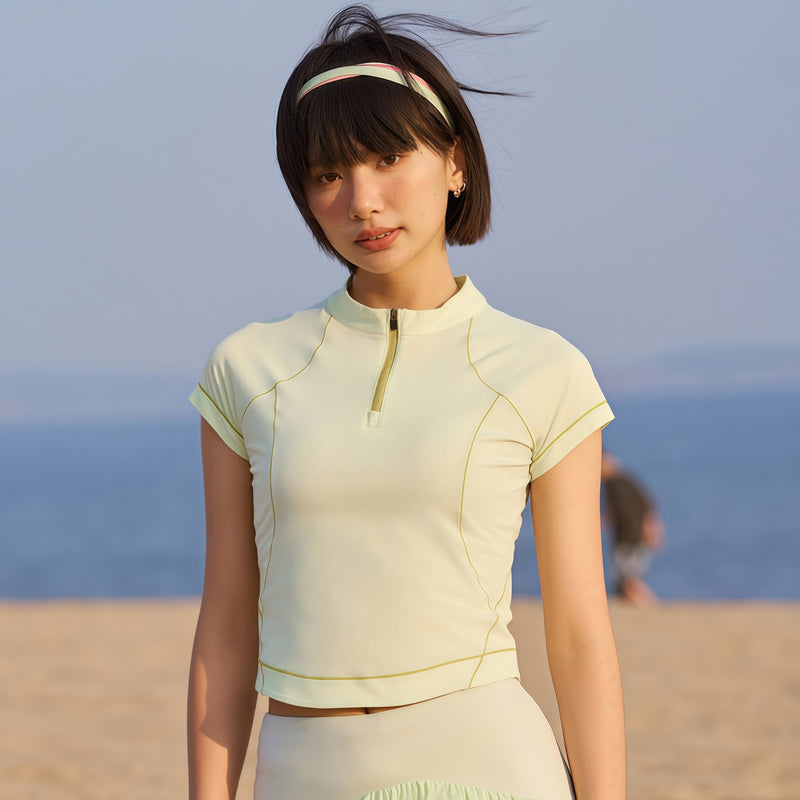 Women's wrinkle-resistant half-zip top - lime cream half-zip short sleeve tee on women with headband, front view at beach