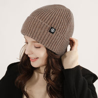 
                  
                    Warm wool knit beanie for winter sports - camel wool snow beanie on women, worn side view, for hiking and trail walking
                  
                