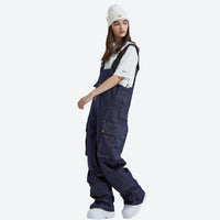
                  
                    Breathable waterproof jean-style suspender ski pants - navy denim bib snow pants with white tee, for skiing and snowboarding
                  
                