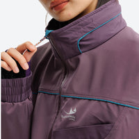 
                  
                    Unisex waterproof softshell jacket and cargo pants - purple, collar close-up with hand, for hiking and travel
                  
                