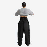 
                  
                    Men's waterproof 2L pullover snow jacket and pants - black snow pants, on-model back view, for cold-weather winter sports
                  
                