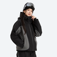 
                  
                    Women's colorblock snowboard jacket with wide-leg pants - black wide-leg snow pants with white top, on-model side view
                  
                
