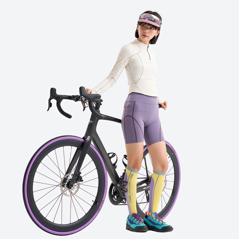 Women's wrinkle-resistant half-zip top - cream white half-zip long sleeve tee on women with cap, bike side view