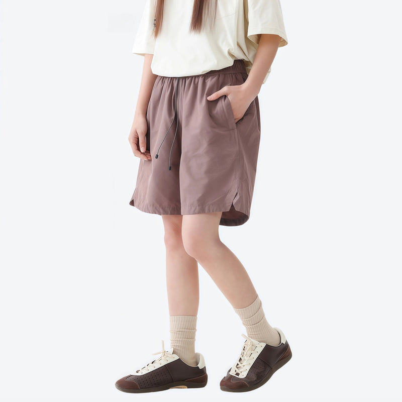 Unisex nylon quick-dry shorts - coffee brown quick-dry shorts with black tee, side walking view, for travel and city walks