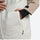 Women's waterproof 2L snow jacket and pants - tan and cream, side pocket close-up with hand, for skiing and snowboarding
