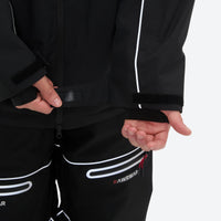 
                  
                    Men's 2-layer snowboard jacket and pants - black jacket, hem cinch close-up with hand, for skiing and snowboarding
                  
                