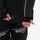 Men's 2-layer snowboard jacket and pants - black jacket, hem cinch close-up with hand, for skiing and snowboarding