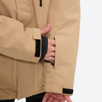 
                  
                    Men's breathable ski jacket with flap pockets - tan jacket, cuff strap close-up with hand, for cold-weather winter sports
                  
                