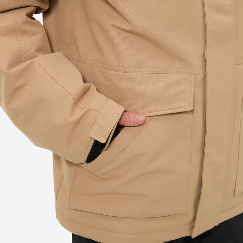 Men's 2-layer snowboard jacket and bib pants - tan jacket, flap pocket close-up with hand, for cold-weather winter sports
