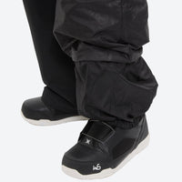 
                  
                    Unisex waterproof 3L bib snow pants - black, hem gaiter over boot side close-up detail, for cold-weather winter sports
                  
                