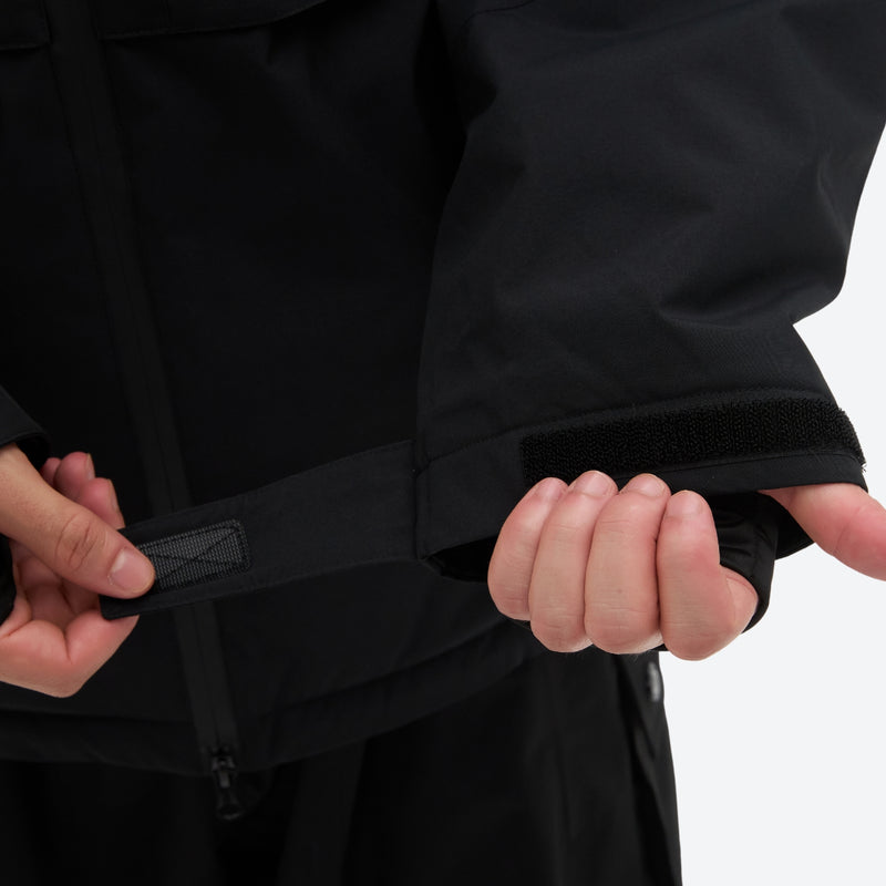 Men's waterproof 3L snow jacket and pants series - black, cuff strap close-up with hand, for powder and piste riding