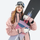 Blizzard snow mittens with three layer warmth - pink snow mittens on women in pink jacket with snowboard, front standing view