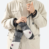 
                  
                    Insulated snow mittens for cold resort days - gray snow mittens on model in beige jacket, for snow sports weekends
                  
                
