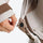 Breathable rain shell with extended hood brim - beige gray, cuff strap close-up with hand, for cold-weather outdoor wear