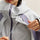 Breathable rain shell with extended hood brim - light gray, collar zip close-up with hand, for skiing and snowboarding