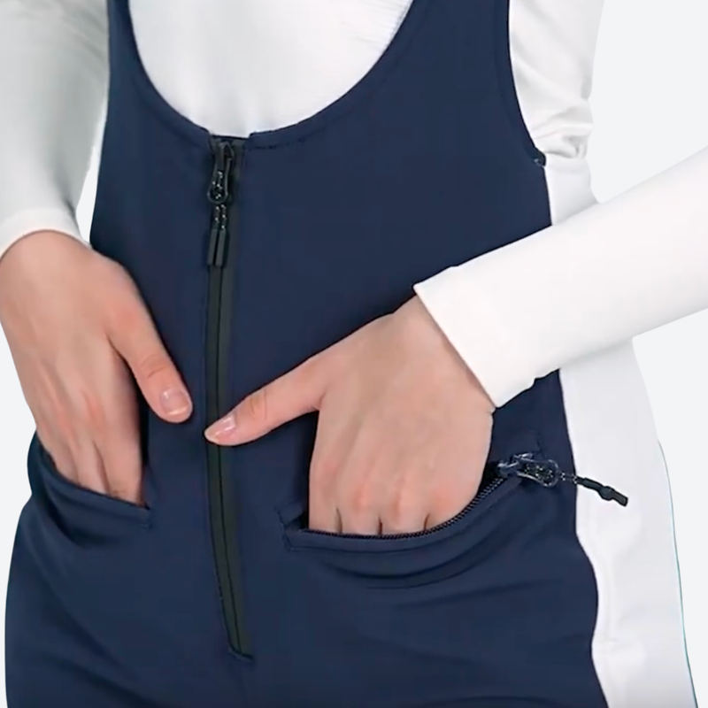 Women's slim fit waterproof ski bib pants - navy slim fit ski bib, waist pocket both hands close-up, for snow sports weekends