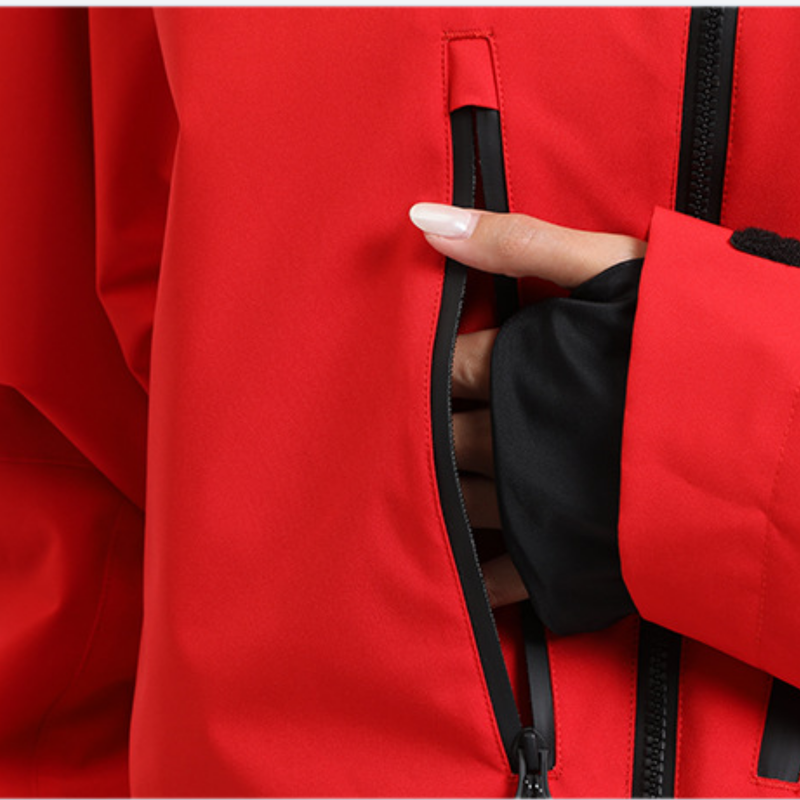 Men's adjustable ski pants with suspenders - red, chest zip close-up with hand, for deep powder winter days