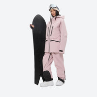 
                  
                    Women's 3L waterproof suspender snow pants - pink, on-model front with upright snowboard, for skiing and snowboarding
                  
                