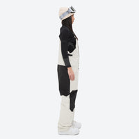 
                  
                    Women's adjustable ski pants with suspenders - white bib pants, on-model side view, for resort and backcountry days
                  
                