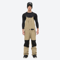 
                  
                    Insulated bib snow pants for men - tan bib pants with black knee patches, for resort and backcountry days
                  
                