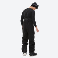 
                  
                    Men's adjustable ski pants with suspenders - black bib pants, on-model side view, for cold-weather winter sports
                  
                
