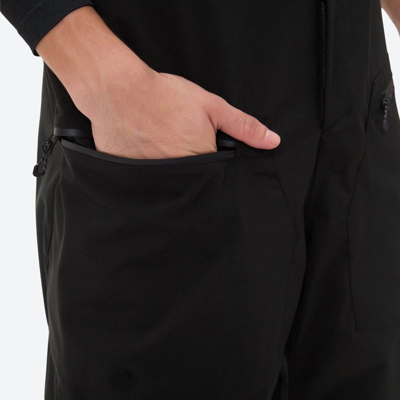 Men's 3L waterproof suspender snow pants - black bib pants, side pocket close-up with hand, for skiing and snowboarding