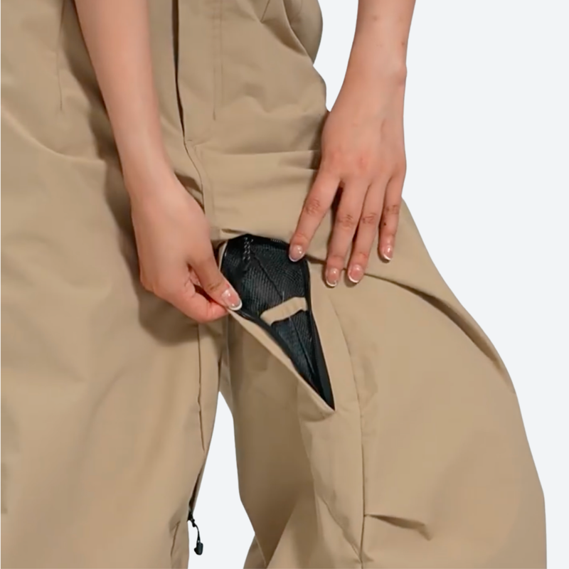Men's waterproof 3L cargo snow pants - tan, mesh vent close-up with hand, for cold-weather winter sports