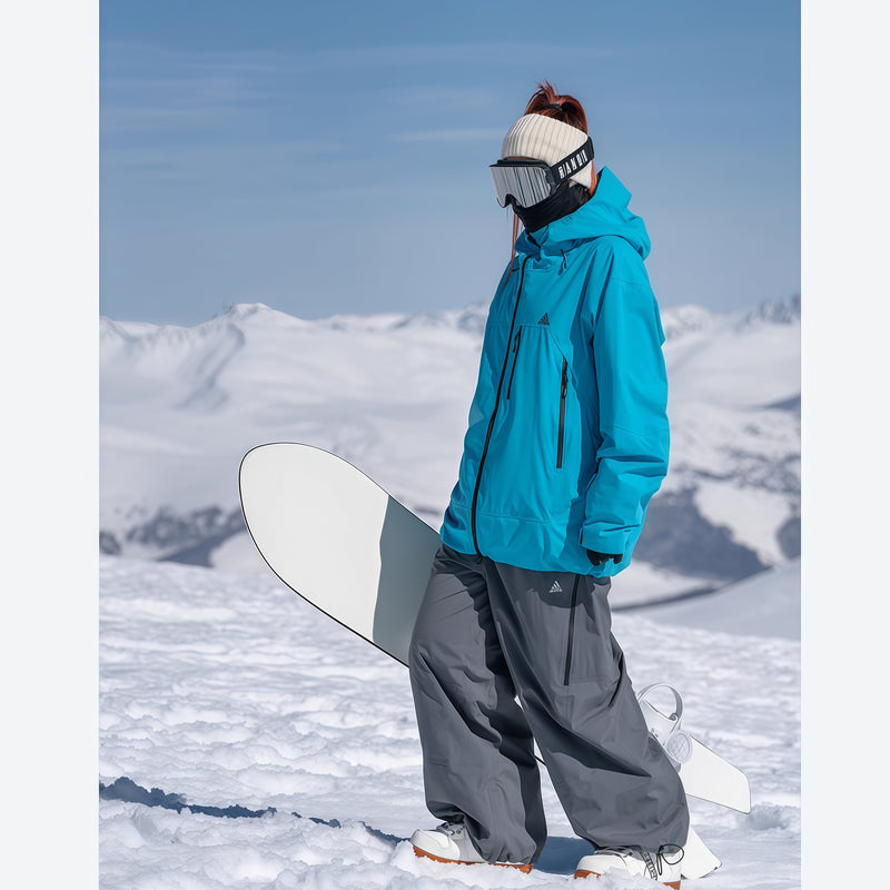 Women's insulated snowboard jacket with cuff gaiters - blue insulated jacket with gray pants, for resort and backcountry days