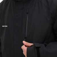 
                  
                    Unisex waterproof 2L snow jacket and bib pants series - black, chest zip close-up with hand, for powder and piste riding
                  
                