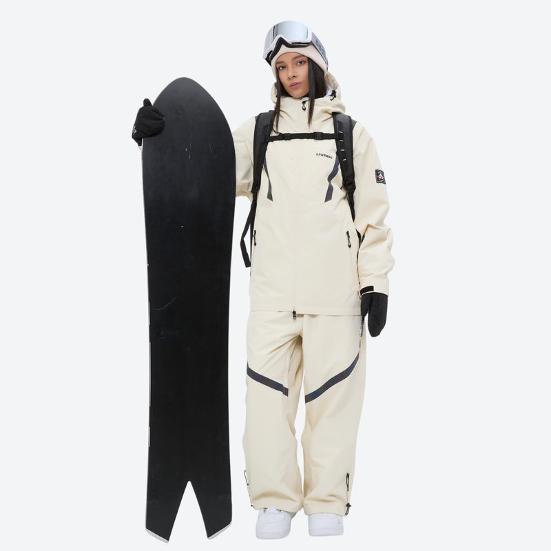 Breathable ski jacket and snow pants combo - cream, on-model front holding snowboard, for resort and backcountry days