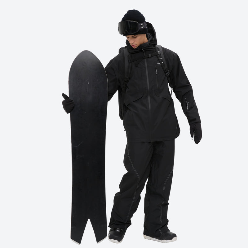 Men's waterproof 2L snow jacket and pants set - black, on-model front with upright snowboard, for resort and backcountry days