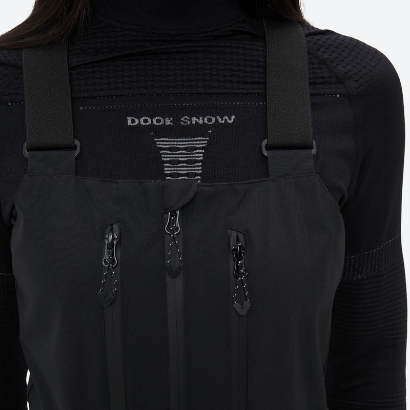 Breathable 3-layer ski bibs with cross-back straps - black, chest zip close-up detail, for resort and backcountry days