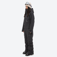 
                  
                    Breathable full-body ski suit with waist belt - black one-piece suit, on-model side view, for powder and piste riding
                  
                