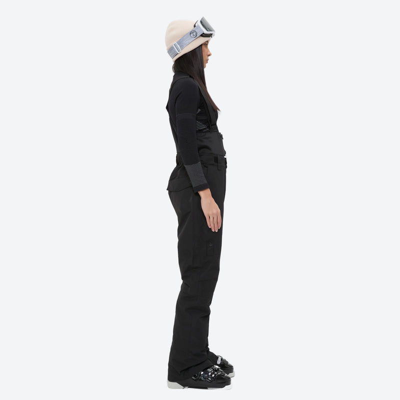 Women's breathable snow jacket with suspender pants - black snow pants, on-model side view, for resort and cross-country days