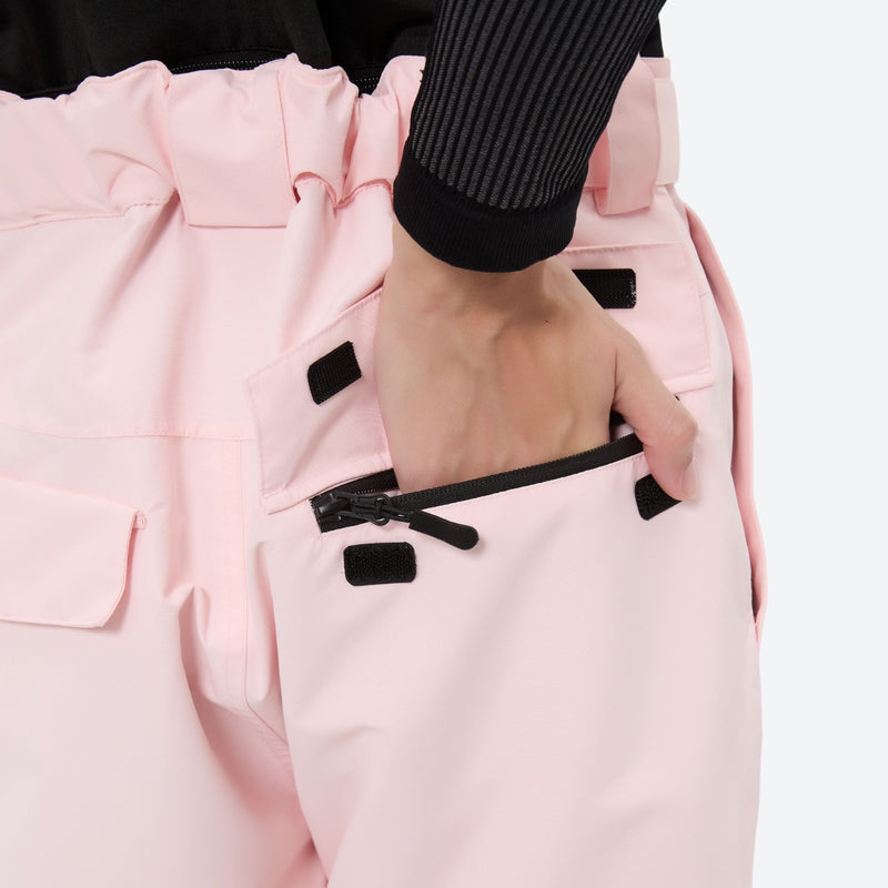Women's 2-layer insulated ski suit - light pink snow pants, back pocket close-up with hand, for snowy mountain travel