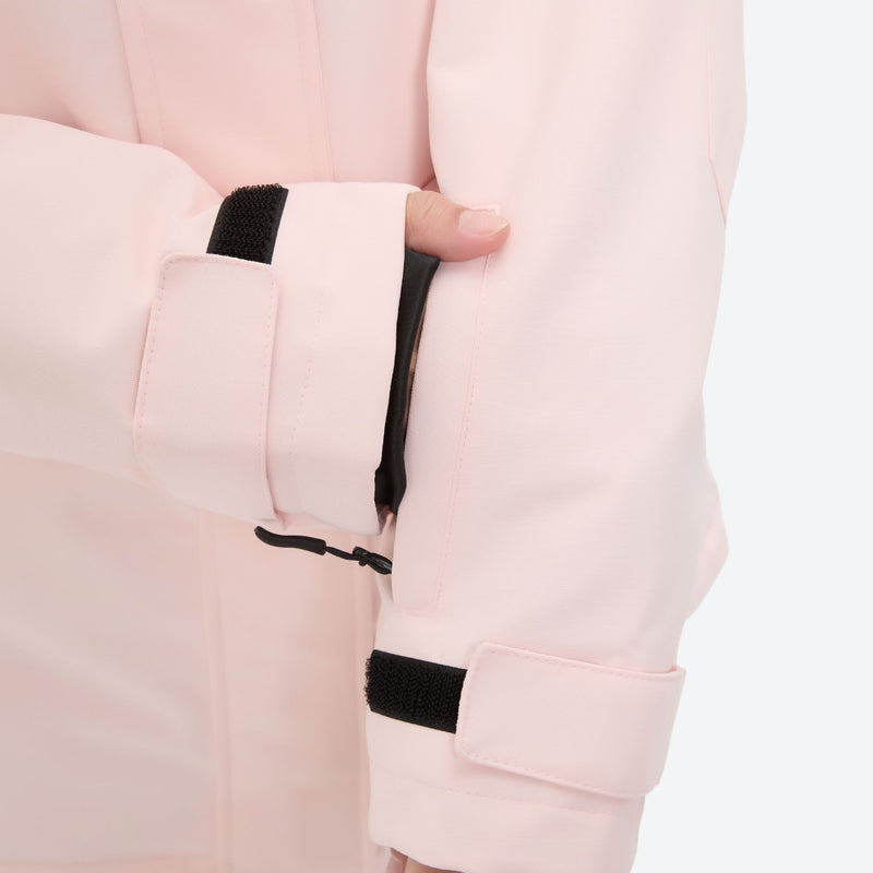 Women's waterproof 2L ski jacket and pants set - light pink, cuff close-up with hand, for resort and cross-country days