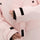 Women's 2-layer insulated ski suit - light pink, cuff strap close-up with hand, for skiing and snowboarding