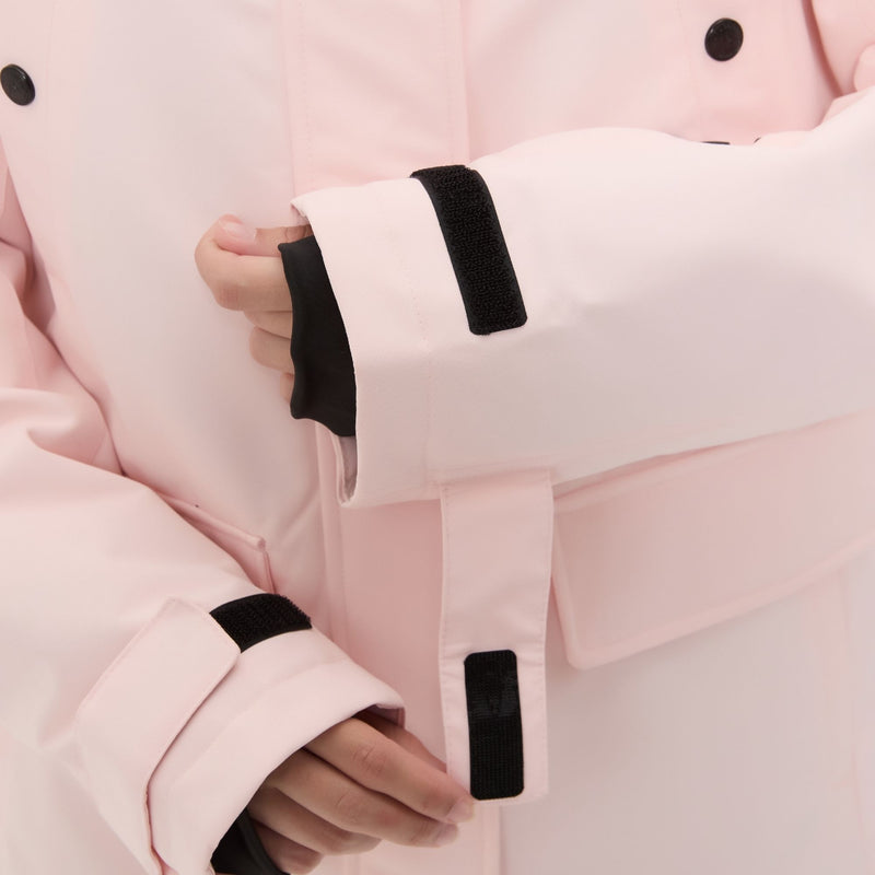 Women's 2-layer insulated ski suit - light pink, cuff strap close-up with hand, for skiing and snowboarding